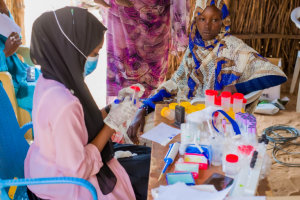 a medical doctor or nurse carrying out consultation with a sudanese woman and prescribing medication