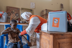 a sudanese doctor clinically examining a sudanese child.